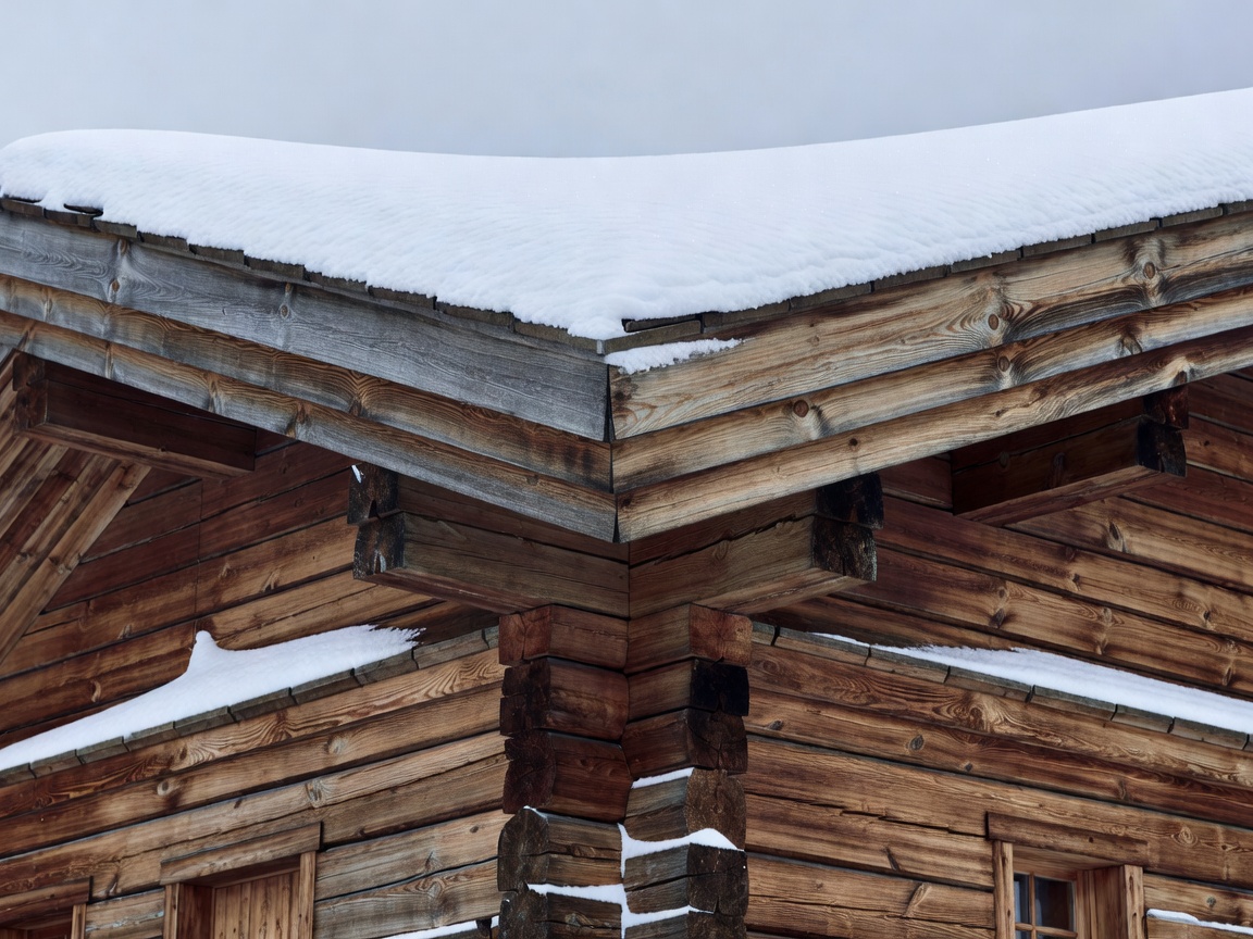 Close detail of heavy timber chalet construction with fresh alpine snow